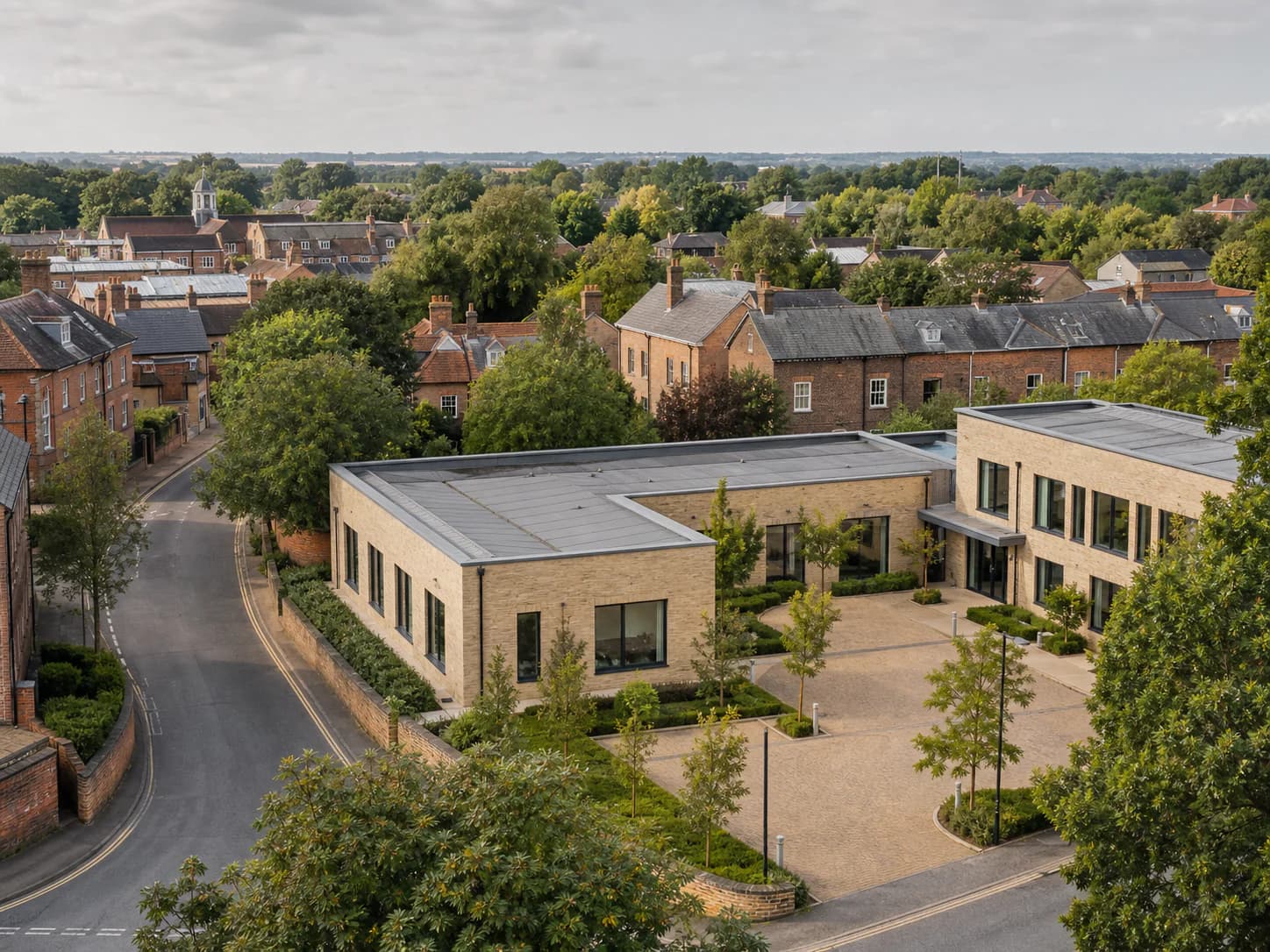 Elevated view of a modern office courtyard among the rooftops and trees of Bicester
